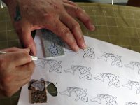 Crist uses an Exacto knife to cut out pattern pieces
